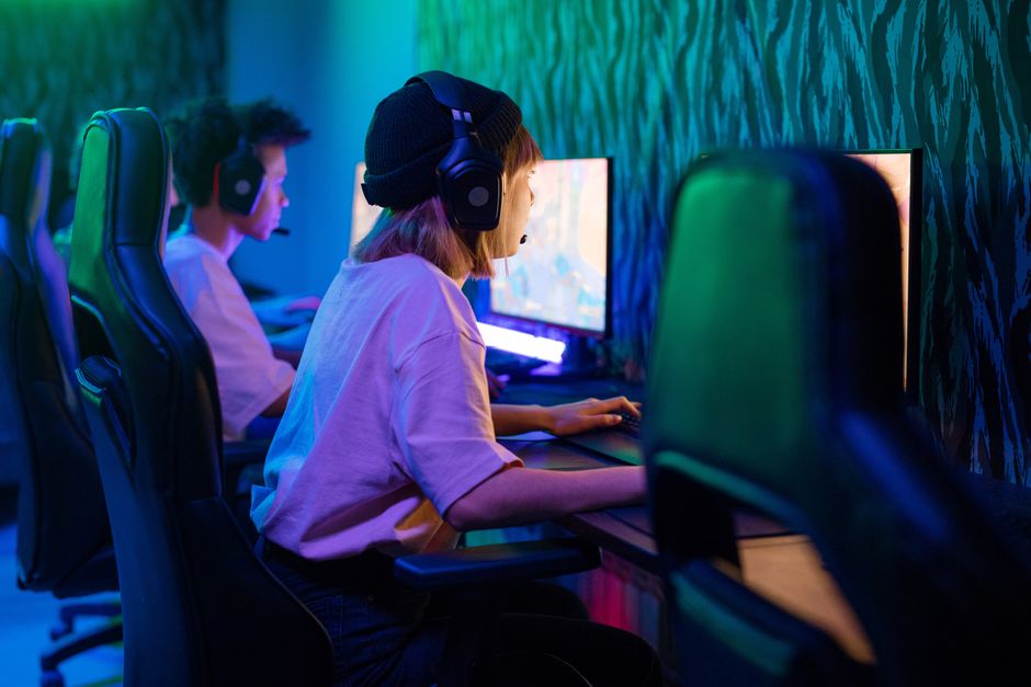 Fókuszált játékosok fejhallgatóval egy e-sport arénában