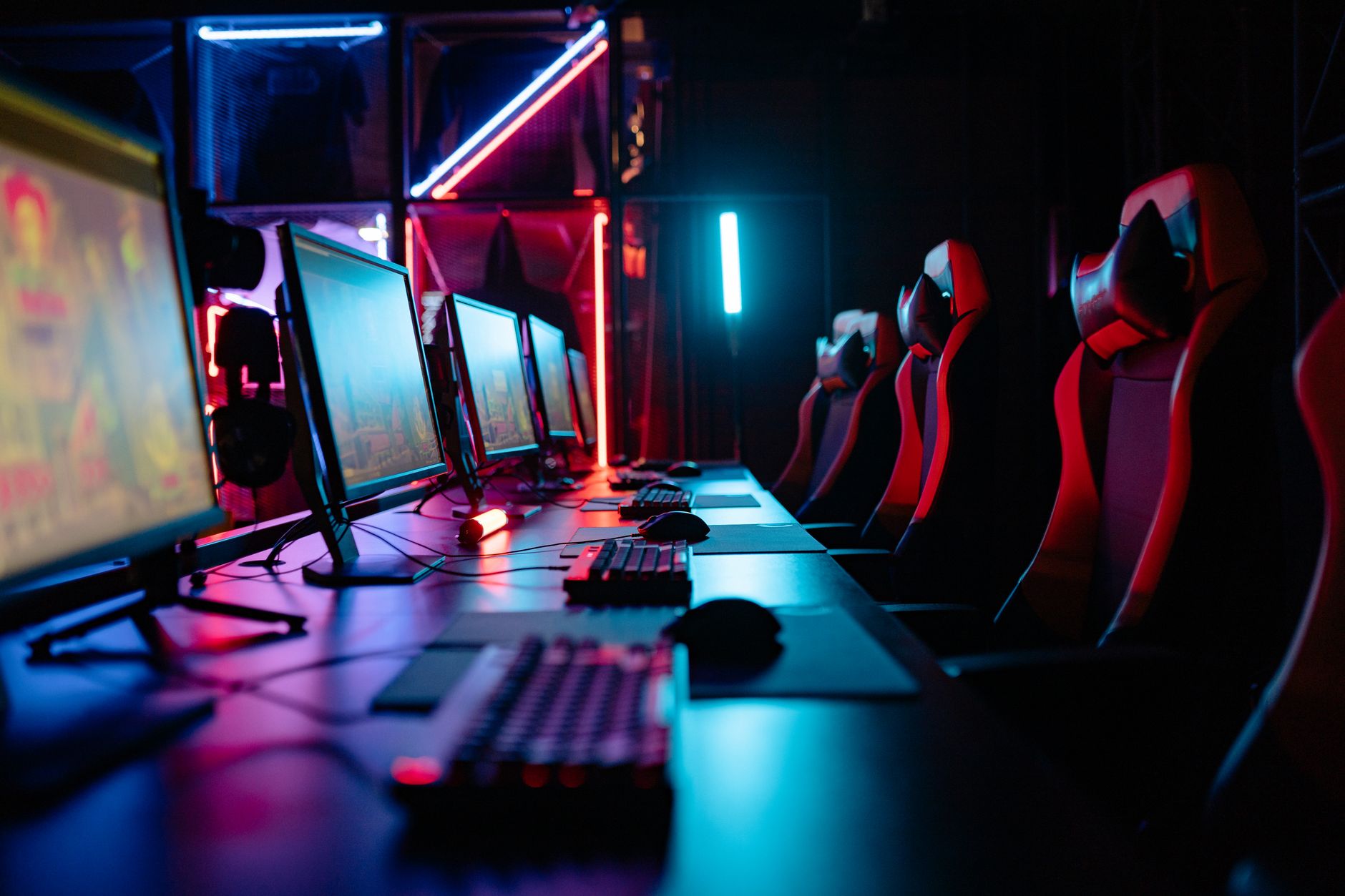 Neonfényes géptermi terem gamer székekkel és számítógépekkel